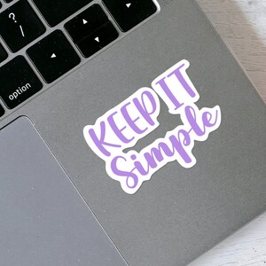 May include: A purple vinyl sticker with the text "KEEP IT SIMPLE" in a handwritten font.