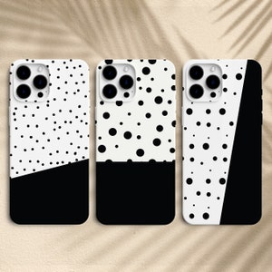 May include: Three black and white phone cases with a polka dot pattern. The top half of each case has a white background with black polka dots. The bottom half of each case is black. The cases have a cut-out for the phone's camera.