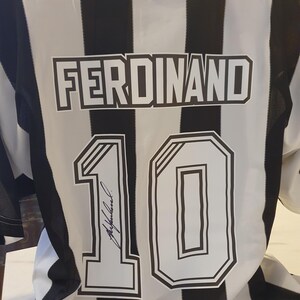 May include: Black and white striped soccer jersey with the name "FERDINAND" and the number "10" on the back. The number is signed in black ink.