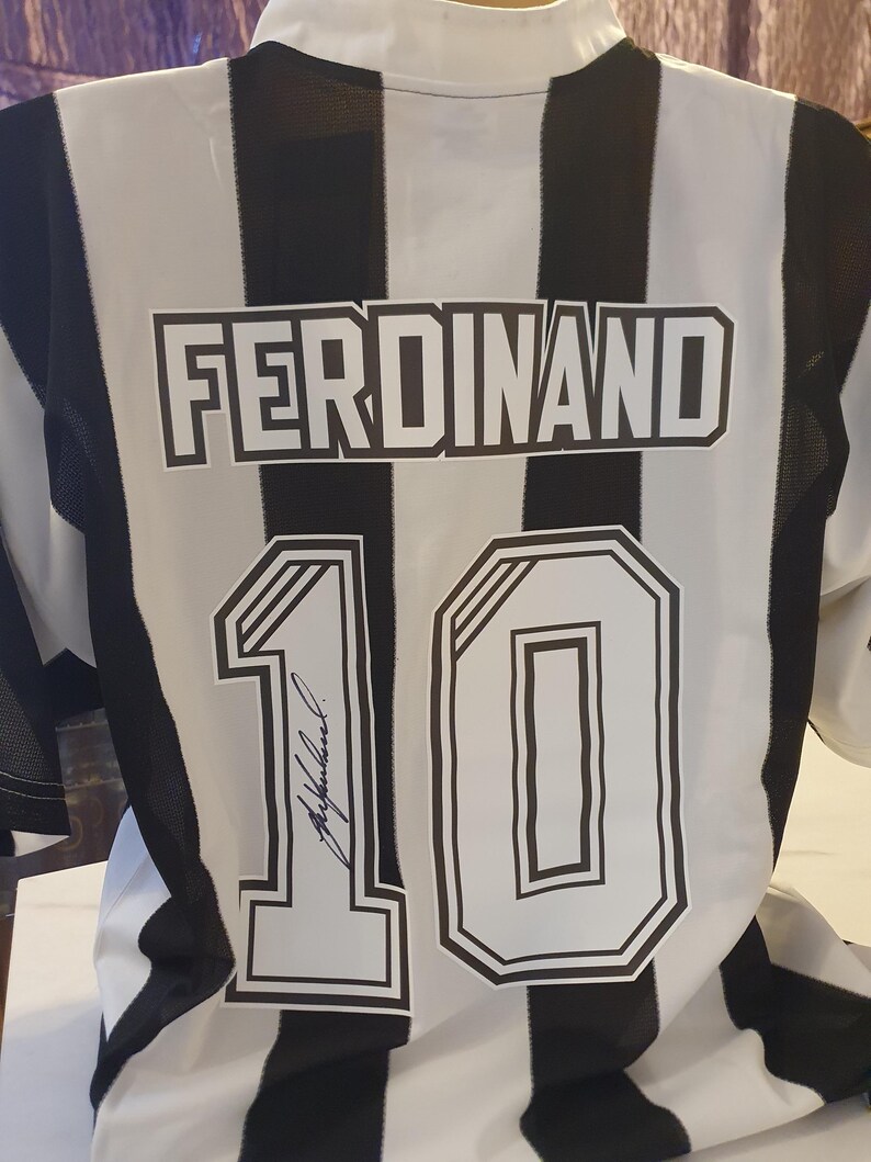 May include: Black and white striped soccer jersey with the name "FERDINAND" and the number "10" on the back. The number is signed in black ink.