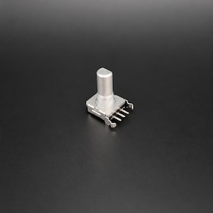 May include: A silver-coloured rotary potentiometer electronic component featuring a cylindrical shaft with a flat side, a threaded mounting bush, and four metal connection pins extending from the base of the rectangular housing.