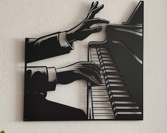 Può includere: Un'opera d'arte da parete in metallo nero che presenta un'illustrazione grafica stilizzata di due mani che suonano i tasti di un pianoforte a coda. Il design è tagliato da un unico foglio di metallo, mostrando la sagoma del piano e delle mani.