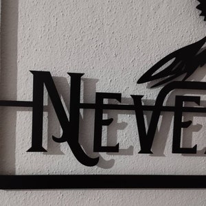 May include: Black metal wall decor featuring the word "NEVER" in a stylised font.