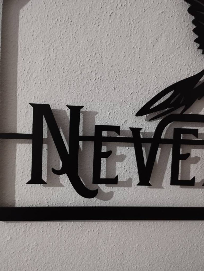 May include: Black metal wall decor featuring the word "NEVER" in a stylised font.