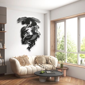 K&ouml;nnte beinhalten: Ein Wandkunstobjekt aus schwarzem Metall mit einem detaillierten Scherenschnitt-Design von zwei fliegenden Kranichen &uuml;ber stilisierten Meereswellen und einer kreisf&ouml;rmigen Sonne. Die komplexe Silhouette zeigt die V&ouml;gel mit ausgebreiteten Fl&uuml;geln.