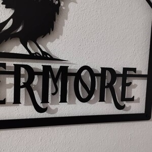 May include: Black metal sign featuring a raven silhouette and the word "Evermore" in a decorative font.