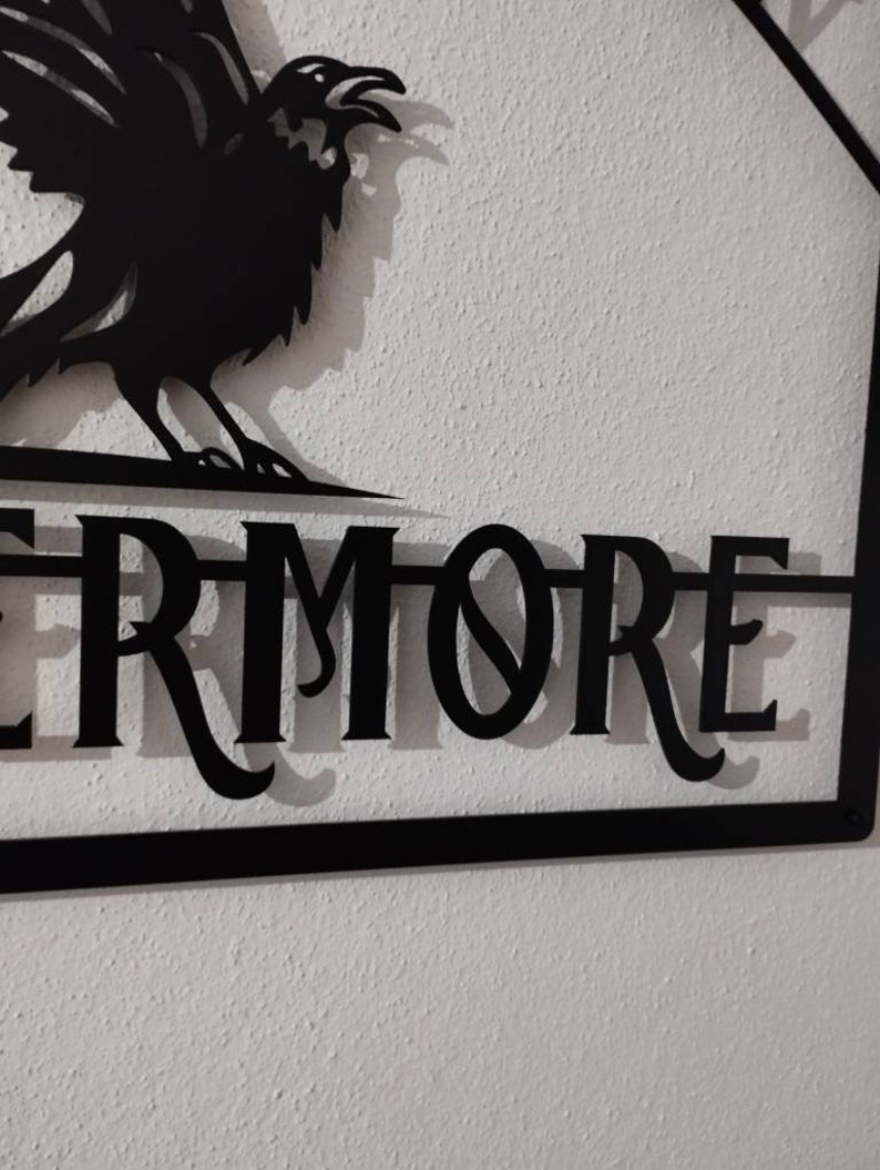 May include: Black metal sign featuring a raven silhouette and the word "Evermore" in a decorative font.