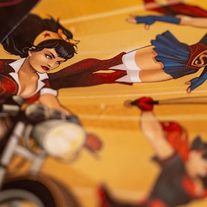 May include: Comic book art featuring Wonder Woman on a motorcycle, Supergirl flying, and a figure swinging a baseball bat. The artwork has a vintage comic book style with bold colors and dynamic poses.