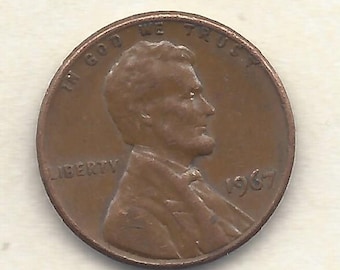 Op de afbeelding: Een koperkleurige Lincoln penny uit 1967. De voorzijde toont een profiel van Abraham Lincoln, met de inscripties "IN GOD WE TRUST" en "LIBERTY". Het jaartal "1967" is ook zichtbaar.