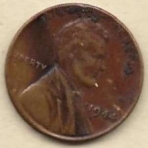 Puede incluir: Primer plano de una moneda de un centavo Lincoln de 1944 de color cobre. El anverso presenta un perfil de Abraham Lincoln, con la palabra "LIBERTY" y el año "1944" visibles. La moneda muestra signos de desgaste y edad.