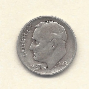 May include: A silver 1948 dime coin. The coin shows a profile of a man facing left, with the word "LIBERTY" above and "IN GOD WE TRUST" below. The year "1948" is visible on the right side of the coin.