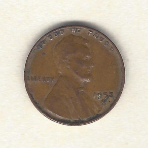 Puede incluir: Una moneda de cobre Lincoln de 1953. La moneda presenta el perfil de Abraham Lincoln, con las inscripciones "IN GOD WE TRUST" y "LIBERTY". El año "1953" es visible debajo del perfil.