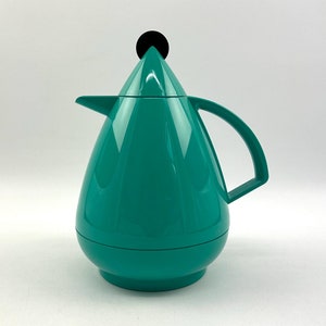 May include: A teal blue thermal carafe with a black lid and a handle. The carafe is shaped like a teardrop.