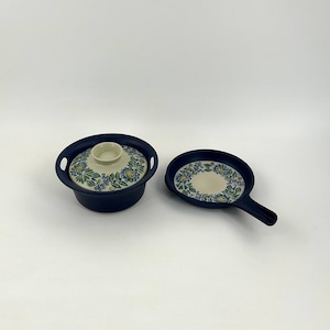 May include: A set of two blue ceramic cookware pieces with a floral design. The pieces include a covered pot and a frying pan.