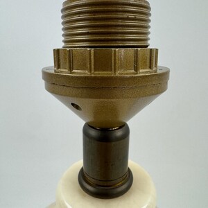 Peut inclure: Gros plan sur un pied de lampe cr&egrave;me avec un col en m&eacute;tal couleur laiton et une douille. Le pied de la lampe est de forme arrondie et la douille est con&ccedil;ue pour accueillir une ampoule standard. La lampe est probablement pour la d&eacute;coration int&eacute;rieure.