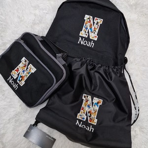 May include: A black backpack, lunch bag, and drawstring bag set with a Mickey Mouse character print. Each bag has a white letter 'N' with the name 'Noah' embroidered below.