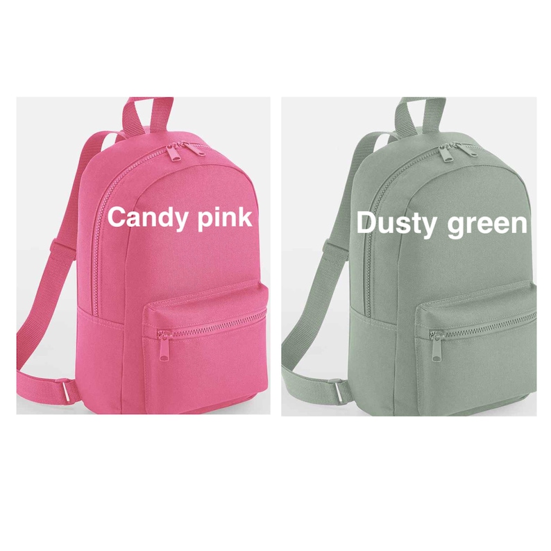 May include: Two backpacks shown side by side. The left backpack is candy pink and the right backpack is dusty green. Each bag features a main zippered compartment, a smaller front zippered pocket, adjustable shoulder straps, and a top handle.