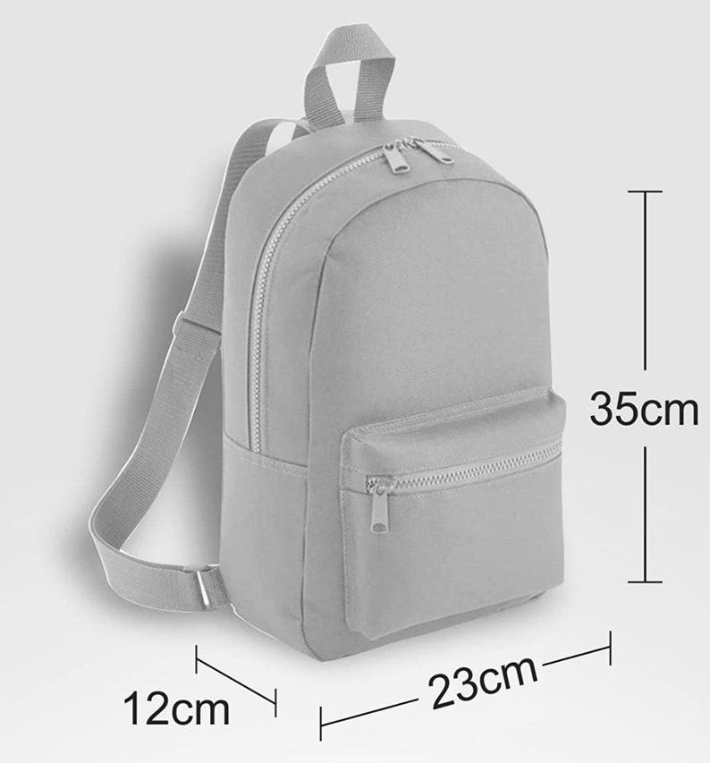 May include: A light gray backpack with a main zippered compartment, a smaller front zippered pocket, and adjustable shoulder straps. The backpack measures 35 cm in height, 23 cm in width, and 12 cm in depth as indicated by the visible dimension lines.