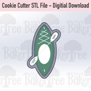 May include: A green and gray cookie cutter in the shape of a kayak with a paddle. The cookie cutter is designed for making cookies.