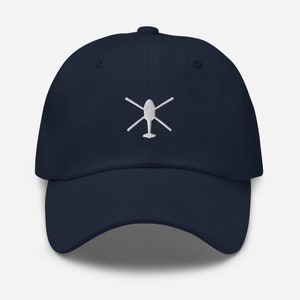 May include: A navy blue baseball cap with a white embroidered helicopter design.