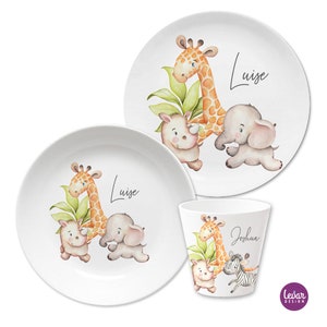 Könnte beinhalten: Ein Set aus drei weißen Melamintellern und einer Tasse mit Dschungeltier-Motiv. Die Teller zeigen eine Giraffe, ein Nashorn und einen Elefanten mit dem Namen "Luise" darauf. Die Tasse zeigt eine Giraffe, ein Nashorn, ein Zebra und den Namen "Joshua" darauf.
