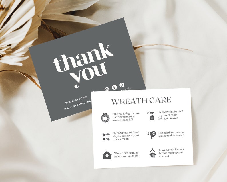 May include: Two cards with text. The first, a dark gray square, reads "thank you" in large white letters, with a business name and website address below. The second card, white, details "WREATH CARE" instructions with icons.