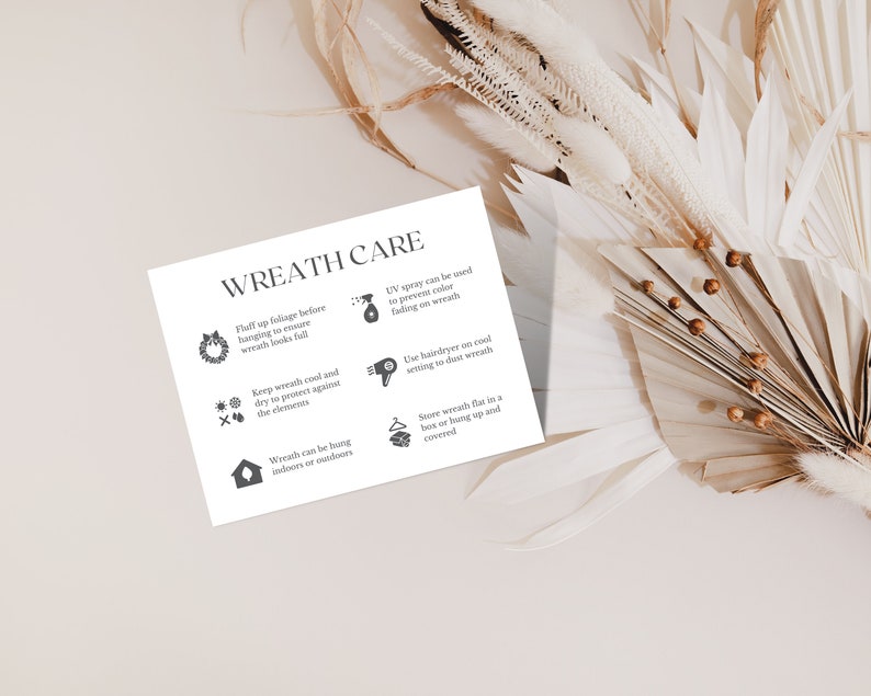 May include: A white card with the text "WREATH CARE" and care instructions for wreaths. The instructions include fluffing foliage, keeping the wreath cool and dry, and using UV spray. The card is surrounded by dried flowers.