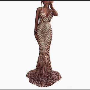 Könnte beinhalten: Ein langes, gold- und weiß-paillettenbesetztes Kleid mit tiefem Ausschnitt und figurbetonter Silhouette. Das Kleid hat einen Meerjungfrauen-Rock.