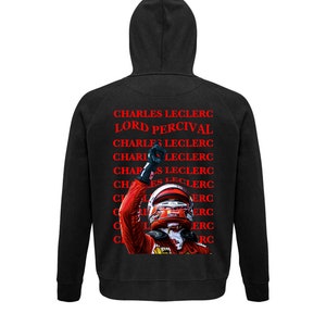 May include: Black hooded sweatshirt with a red and white image of a racing driver, and the text "CHARLES LECLERC" and "LORD PERCIVAL" in red. The sweatshirt has a drawstring hood and long sleeves.