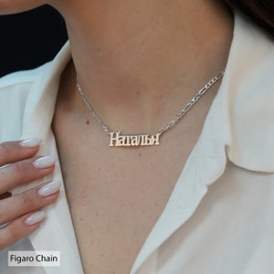 May include: A silver necklace with a Figaro chain and a nameplate pendant that reads "Наталя".