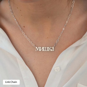 May include: A silver chain necklace with a nameplate pendant that reads "МИШКА". The chain is a link chain style.