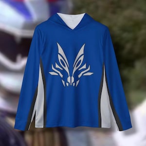 Puede incluir: Una sudadera con capucha azul de manga larga con ribetes blancos y negros. La sudadera presenta un diseño estilizado de cabeza de lobo gris en la parte delantera.