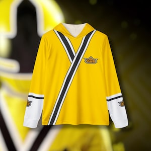 May include: Yellow long-sleeve hoodie with black and white accents. The hoodie features a V-shaped design with black stripes and a small emblem on the chest and sleeves. The sleeves have white cuffs with a black stripe and emblem.
