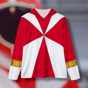 Könnte beinhalten: Langarm-Shirt in Rot und Weiß mit Kapuze. Das Shirt hat ein großes weißes Sternmuster auf der Vorderseite und goldene Einfassungen an den Ärmeln.