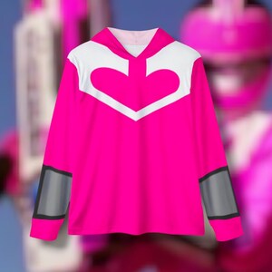 May include: Pink long-sleeved shirt with a white heart-shaped design on the front and gray accents on the sleeves.