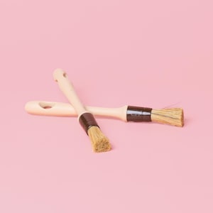 Reinigingsborstel voor raspplaten: klein, minimalistisch, neutrale kleur, ergonomisch ontwerp, functioneel en esthetisch: perfect voor gastronomische recepten.