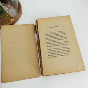 May include: Open vintage book with aged, yellowed pages. The left page is blank, while the right page features printed text with the heading "INTRODUCTION." The book's edges show signs of wear, suggesting its age.