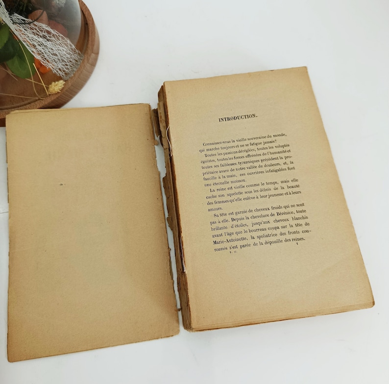 May include: Open vintage book with aged, yellowed pages. The left page is blank, while the right page features printed text with the heading "INTRODUCTION." The book's edges show signs of wear, suggesting its age.