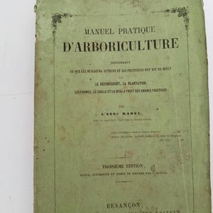 May include: A vintage 1863 book titled Manuel Pratique D'Arboriculture with a faded light green paper cover. The front cover features black printed text detailing the author, L'Abbé Raoul, and publication information from Besançon, France.
