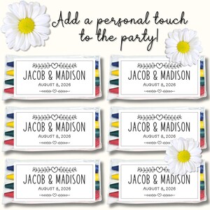 以下が含まれることがあります： 「Add a personal touch to the party!」および「JACOB & MADISON AUGUST 8, 2026」という文字とハートや葉のグラフィックが印刷された白いラベルが付いた、マルチカラーのクレヨン入り透明プラスチック袋6個。白いデイジーの花が添えられています。