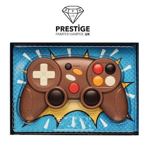 May include: A chocolate video game controller in a clear plastic box with a blue and white comic book style background. The box has the text "PLAY!" on the bottom.