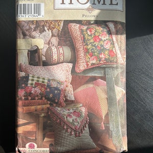 May include: Simplicity Home pillows pattern. The pattern cover showcases a variety of pillow designs, including floral, checkered, and patterned styles. The image displays finished pillows in different shapes and sizes, with a range of fabrics and trims.