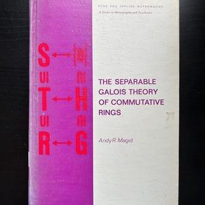 May include: A purple and white book titled "The Separable Galois Theory of Commutative Rings" by Andy R. Magid. The book is part of a series called "Pure and Applied Mathematics: A Series of Monographs and Textbooks".