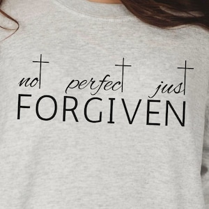 May include: A gray sweatshirt with the text "not perfect just FORGIVEN" and three crosses.