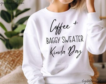 May include: White sweatshirt with the text "Coffee + Baggy Sweater Kinda Day" in black script. The sweatshirt has a crew neck and long sleeves. The image is of a person wearing the sweatshirt.