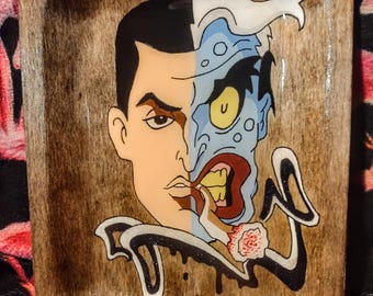 May include: A rectangular wooden tray with a hand-painted illustration of the DC Comics character Two-Face. The artwork depicts the character's split face, with one side normal and the other disfigured. The tray has a dark wood grain finish.