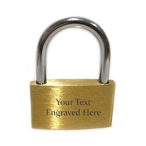 May include: A gold padlock with a silver shackle. The padlock has a brushed finish and the text "Your Text Engraved Here" is engraved on the front.