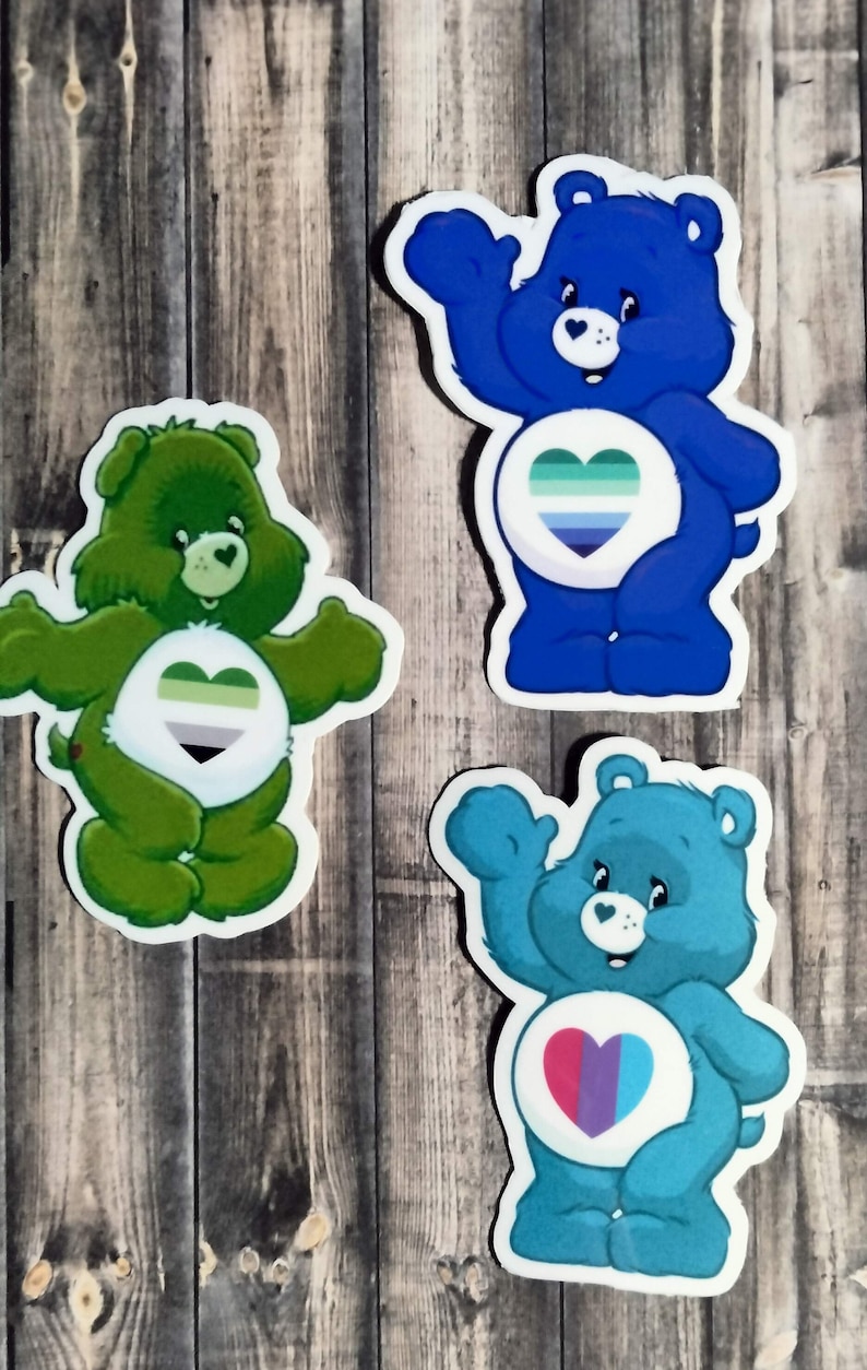 May include: Three Care Bear stickers with different colored fur and hearts. The first sticker is green with a green, gray, and white heart. The second sticker is blue with a blue, green, and white heart. The third sticker is teal with a pink, purple, and blue heart.