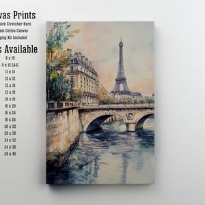 Op de afbeelding: Een aquarel schilderij van de Eiffeltoren in Parijs, Frankrijk. Het schilderij toont de Eiffeltoren in de verte, met een brug en gebouwen op de voorgrond. Het schilderij is verkrijgbaar als canvas print in verschillende maten.