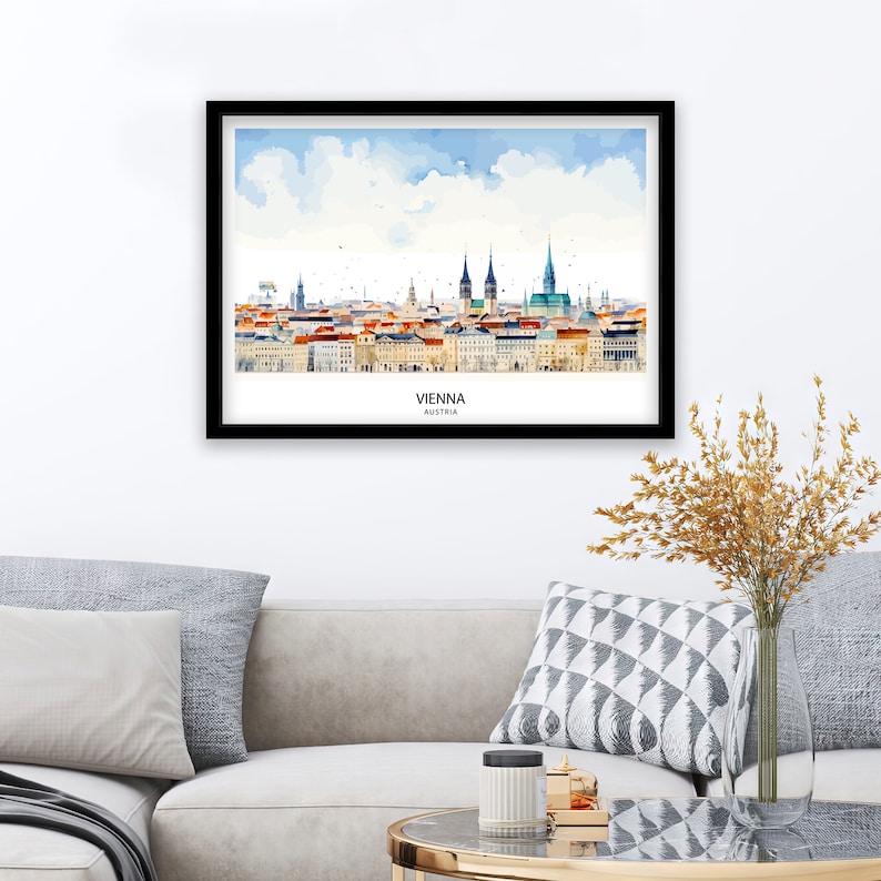 Peut inclure: Une peinture &agrave; l'aquarelle de l'horizon de Vienne, mettant en sc&egrave;ne les b&acirc;timents embl&eacute;matiques de la ville, dont la cath&eacute;drale Saint-&Eacute;tienne. La peinture est sur fond de ciel bleu avec des nuages blancs. Le texte "VIENNA, AUSTRIA" est imprim&eacute; sous l'horizon.